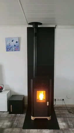 Poêle à granulés Jøtul PF 734 noir, installé devant des protections murales unies noires sur une plaque de sol en acier noir